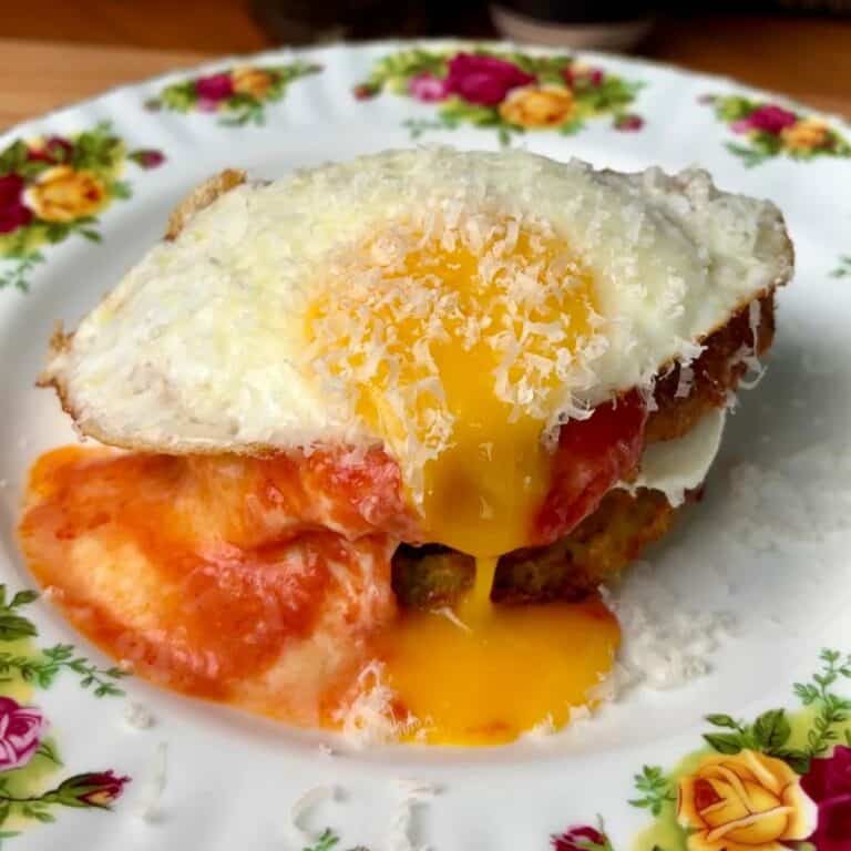 chicken parm potato breakfast waffles topped with a runny egg and parmesan