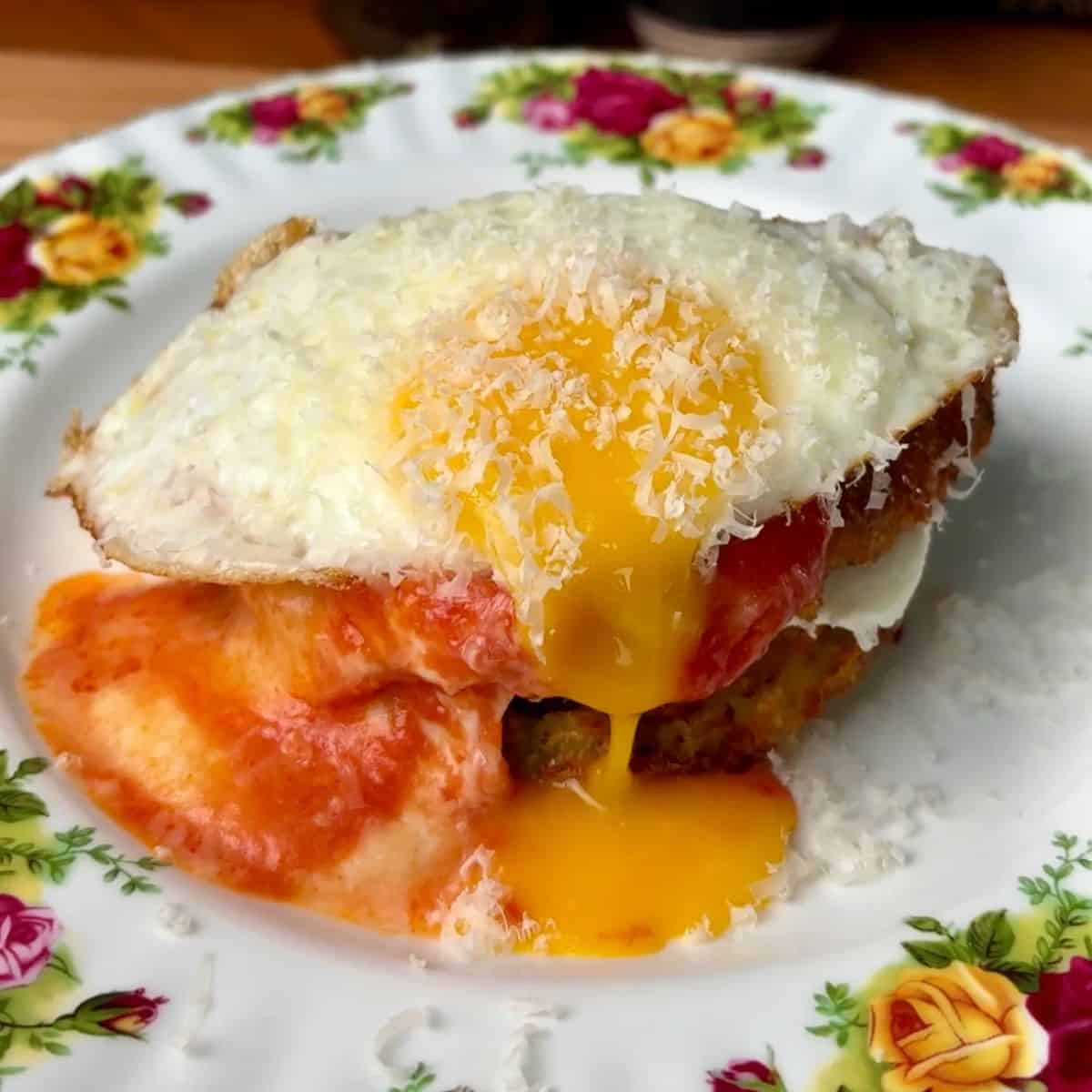 chicken parm potato breakfast waffles topped with a runny egg and parmesan