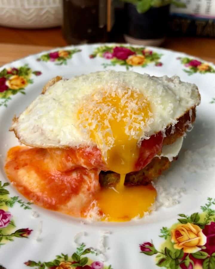 chicken parm potato breakfast waffle with runny egg yolk, tomato sauce and parmesan