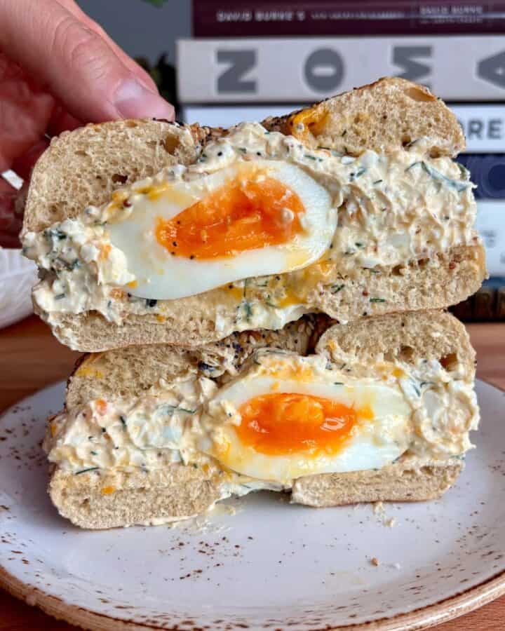everything bagel stuffed with chopped egg salad and a soft boiled egg