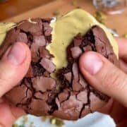 crispy crackly chewy pistachio brownie cookie with pistachio butter in the middle