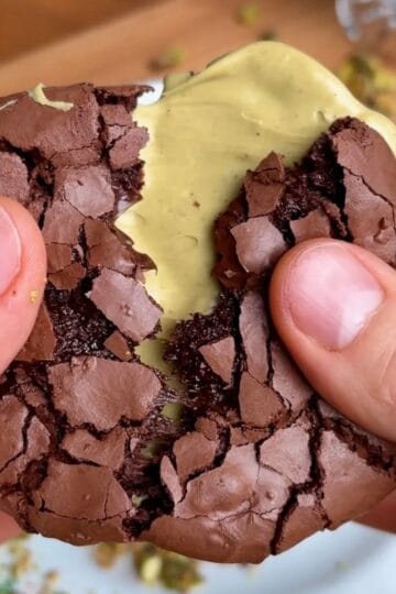 crispy crackly chewy pistachio brownie cookie with pistachio butter in the middle