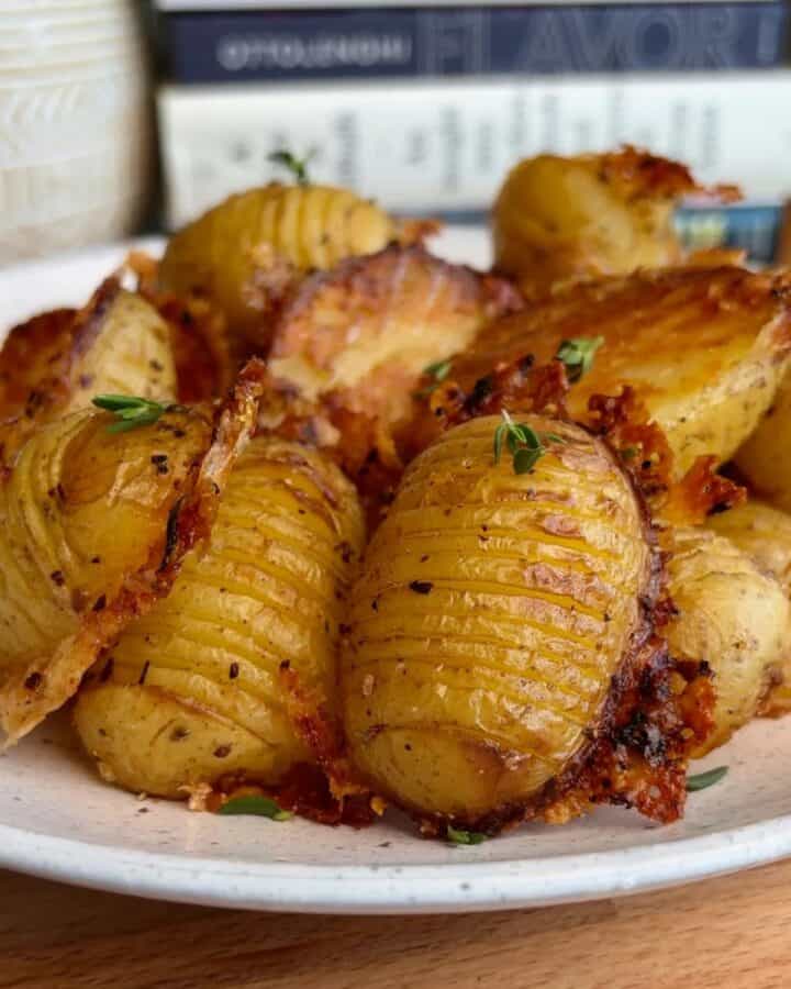 plate of crispy parmesan hasselback potatoes with crispy parmesan edges and fresh microgreen topping
