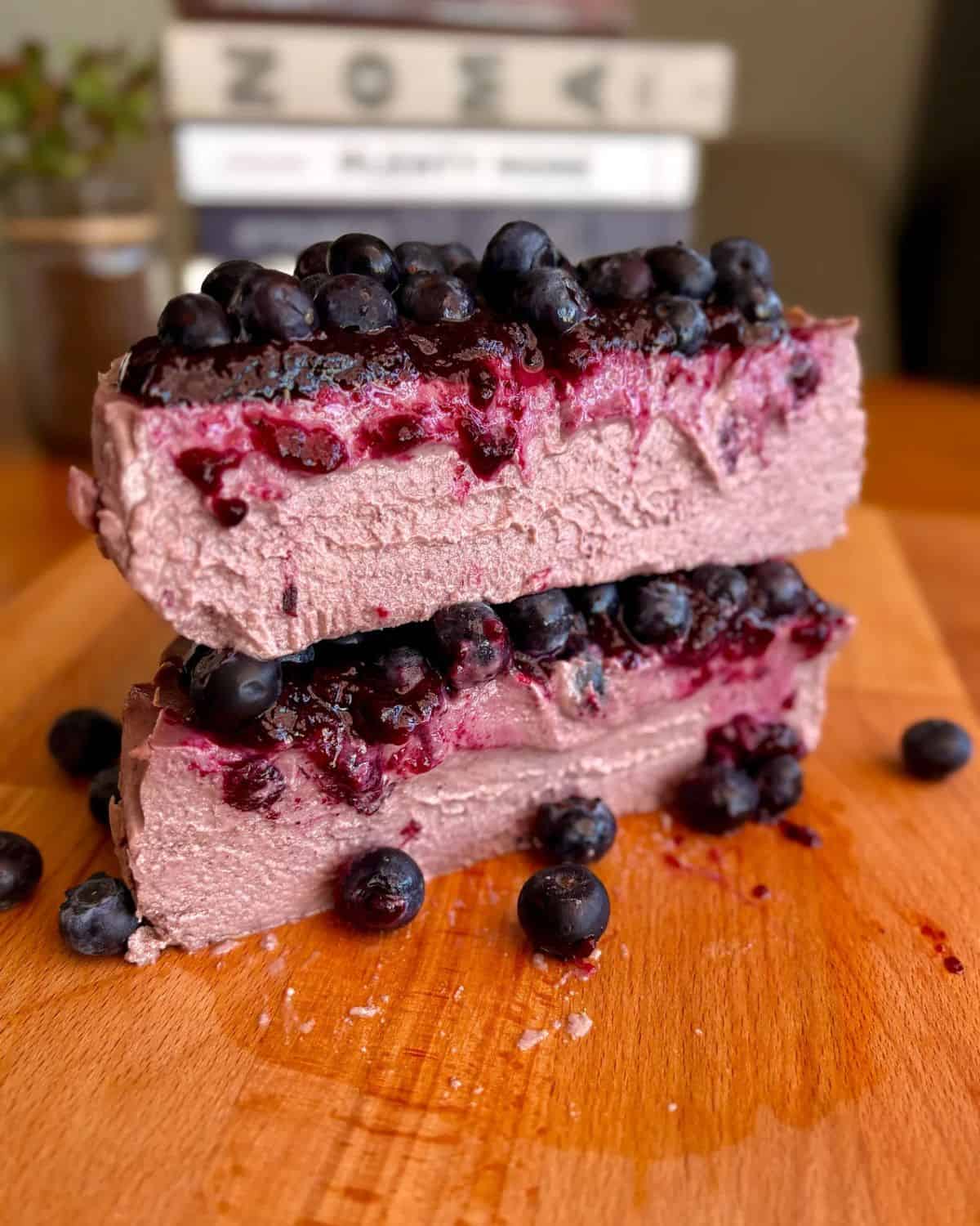 sliced fudgy high protein blueberry cheesecake with blueberry jam and fresh blueberries