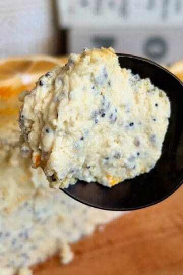 fudgy high protein lemon poppyseed cheesecake with lemon wedge and poppyseed topping