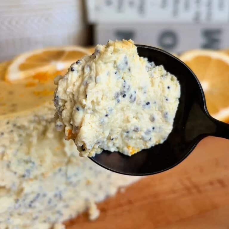 fudgy high protein lemon poppyseed cheesecake with lemon wedge and poppyseed topping