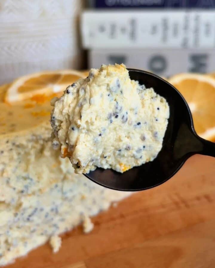 fudgy high protein lemon poppyseed cheesecake with fresh lemon and poppyseed topping