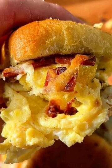 garlic and herb bacon egg and cheese slider on a soft Hawaiian roll with crispy bacon and fluffy eggs