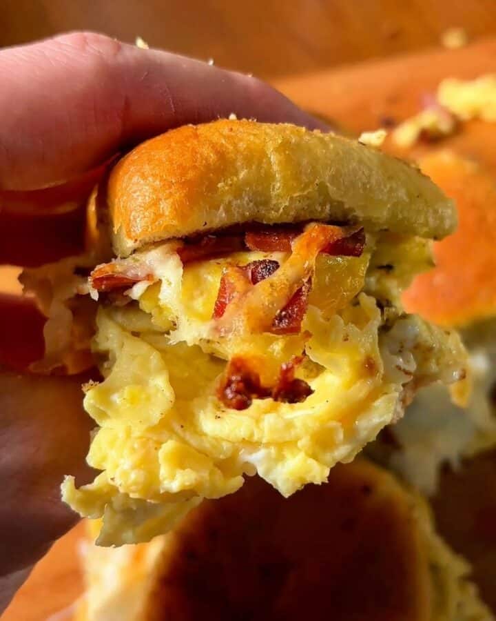 garlic and herb bacon egg and cheese slider on a sweet Hawaiian roll with crispy bacon melty cheese and fluffy eggs