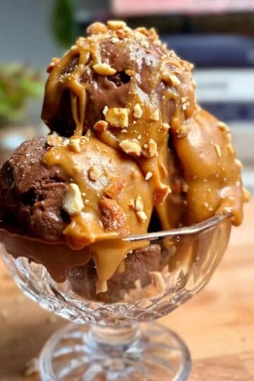 high protein chocolate banana ice cream sundae topped with crushed nuts and caramel sauce
