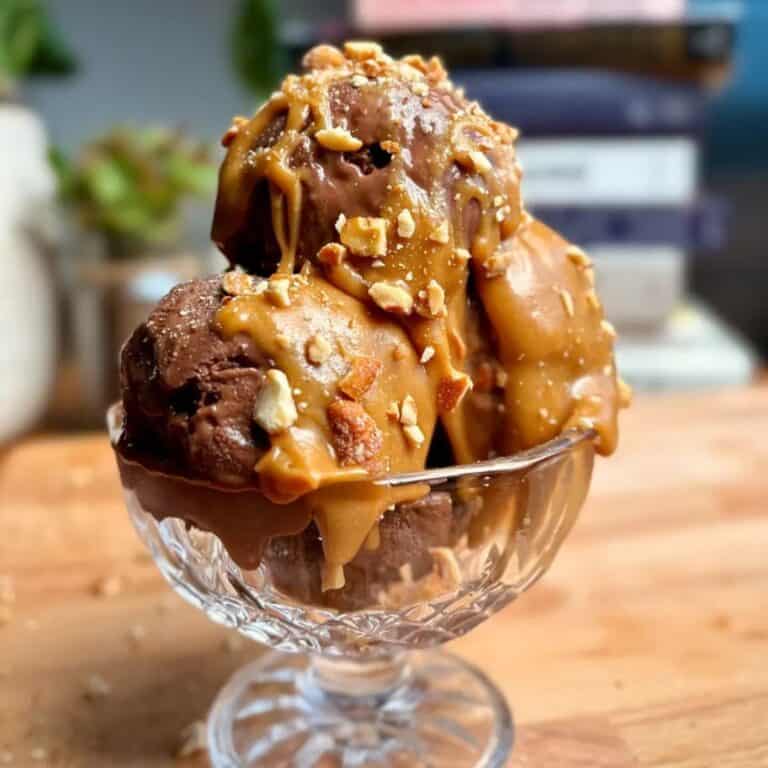 high protein chocolate banana ice cream sundae topped with crushed nuts and caramel sauce