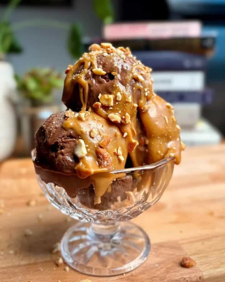 high protein chocolate banana ice cream sundae with caramel drizzle and crushed peanuts