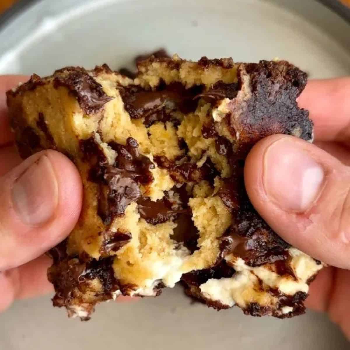 high protein cream cheese stuffed brookie bar with melted chocolate chips in the middle