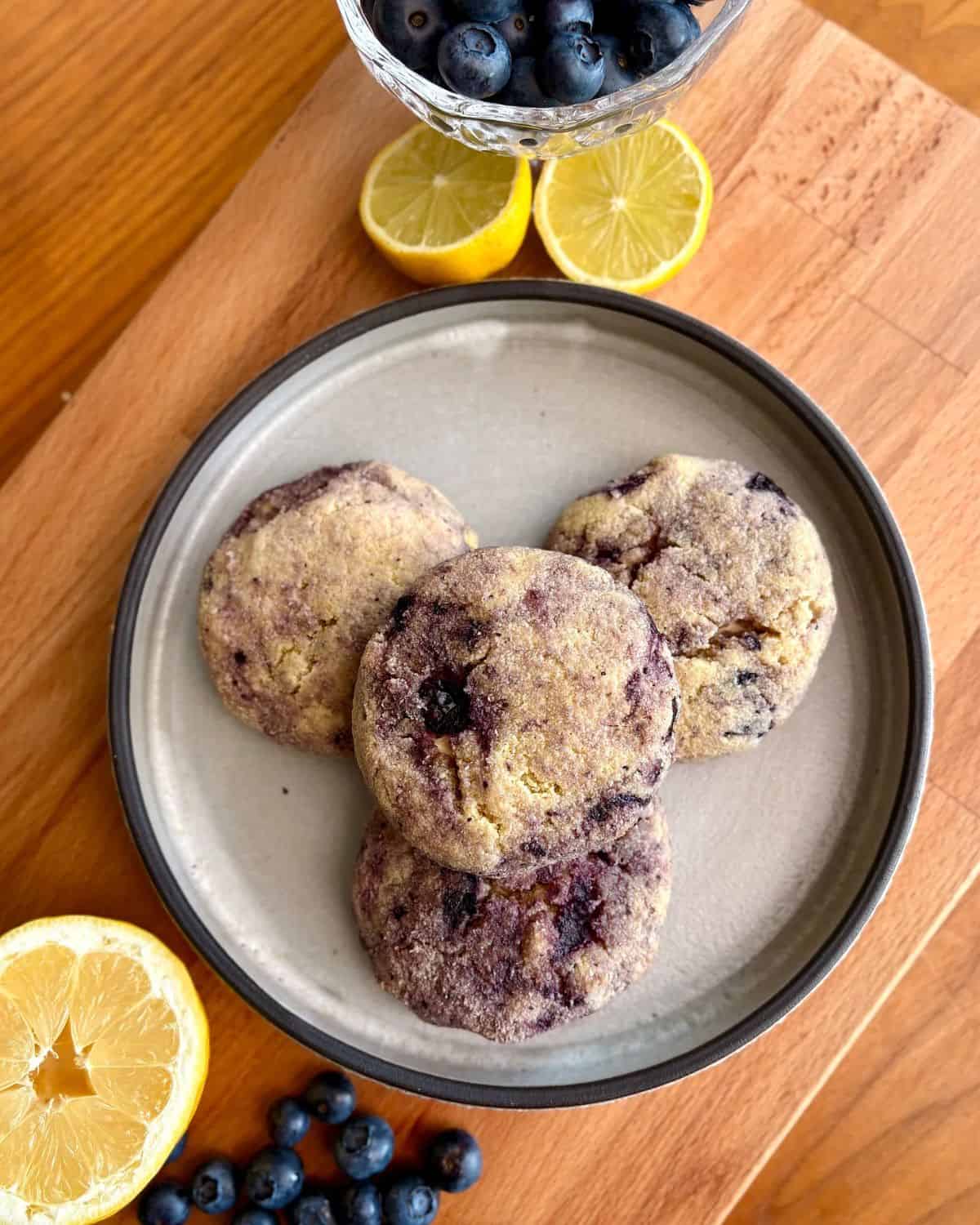 Lemon blueberry cheesecake cookies with blueberries and lemon half