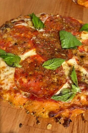 Pepperoni hot honey pizza with sweet potato crust, red pepper flakes and fresh basil
