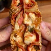 pepperoni pizza rice paper spiral with melted cheese and sesame seeds