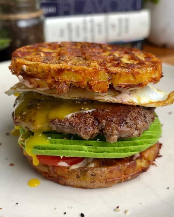 potato waffle breakfast burger with runny egg, crispy beef, sliced avocado and tomato