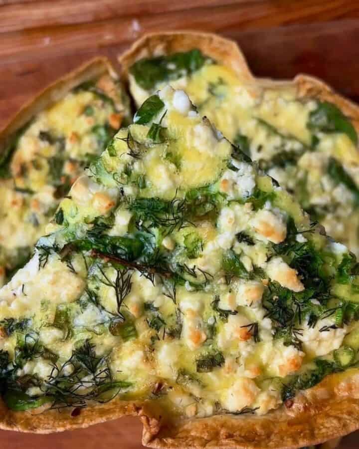 slice of spanakopita tortilla quiche with crispy edges, rosemary and feta