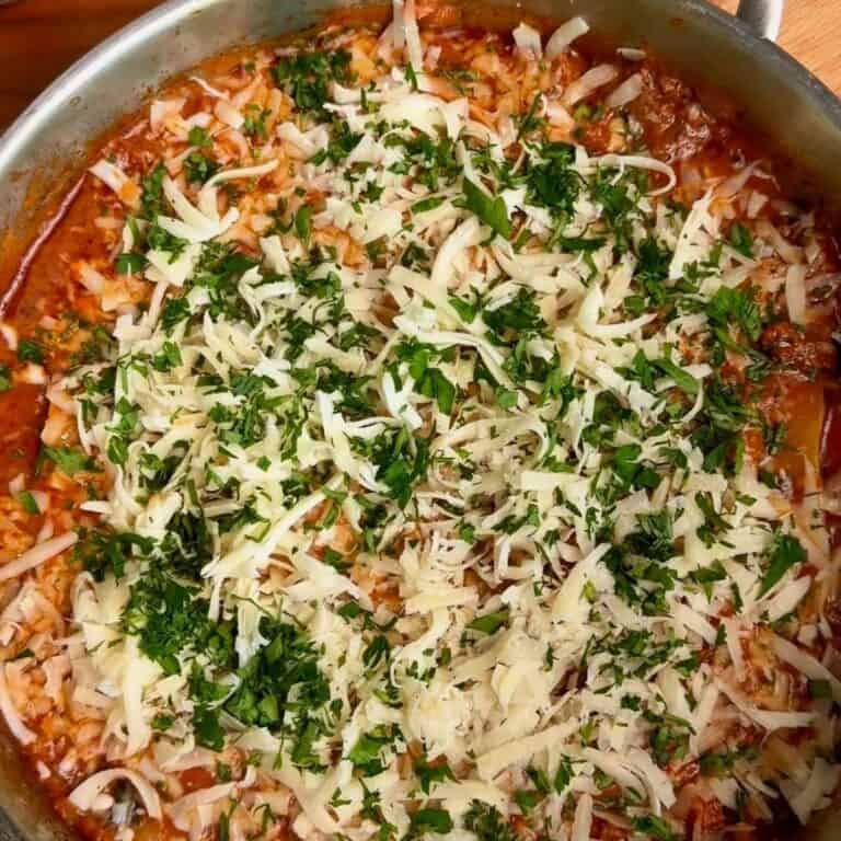 30 minute one pan lasagna ready for the oven with fresh tomato sauce, fresh mozzarella, and fresh parsley on top