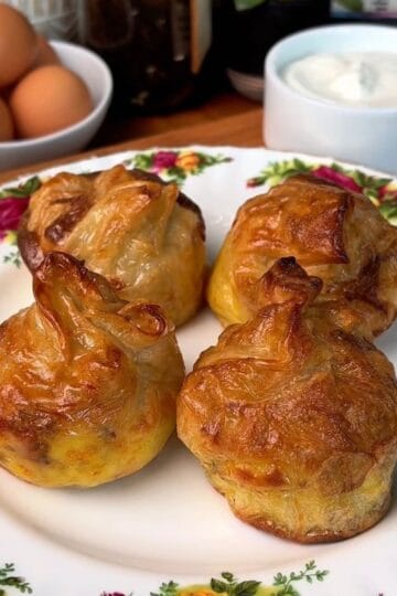 a plate of fresh, crispy, bacon, egg and cheese rice paper dumplings with a side of garlic dip
