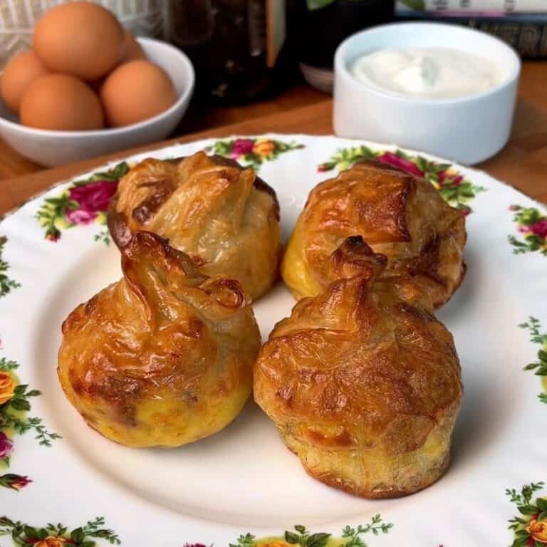 a plate of fresh, crispy, bacon, egg and cheese rice paper dumplings with a side of garlic dip