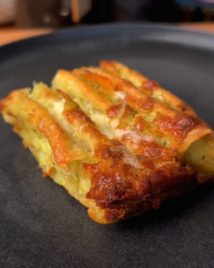 a crispy slice of cheesy garlic and herb tortilla pull apart bread sitting on a plate