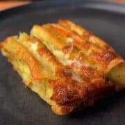 a crispy piece of cheesy garlic & herb tortilla pull apart bread on plate