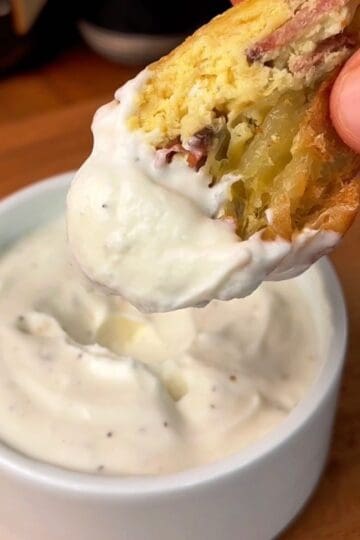 creamy garlic dijon yogurt sauce spread on a bite of a bacon, egg and cheese rice paper dumpling