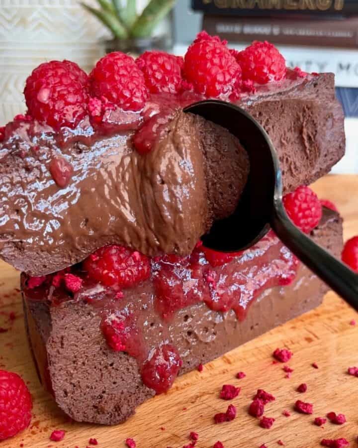 sliced dark chocolate raspberry cheesecake with fudgy chocolate inside, freeze dried raspberries and raspberry jam