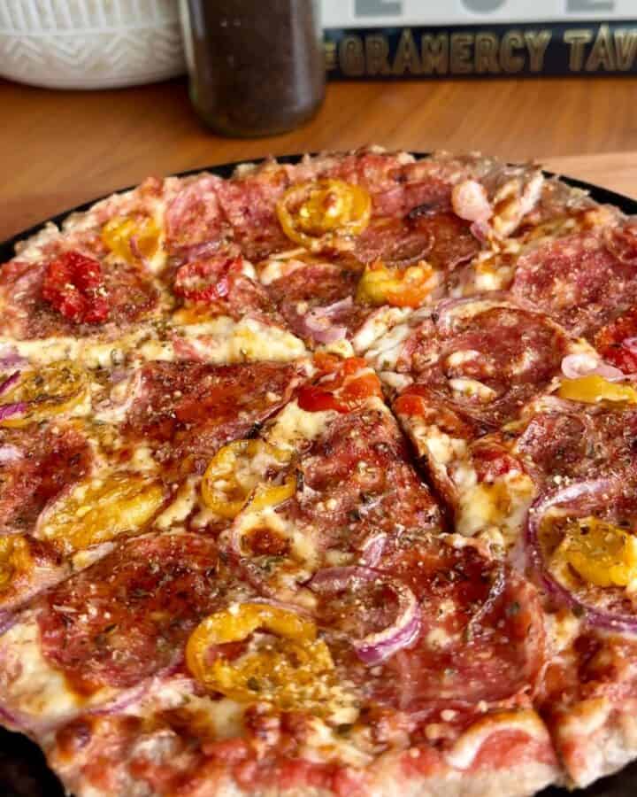 round, crispy hot honey chicken crust pizza topped with melty cheese, hot peppers, pepperoni, and red onion and drizzles of hot honey