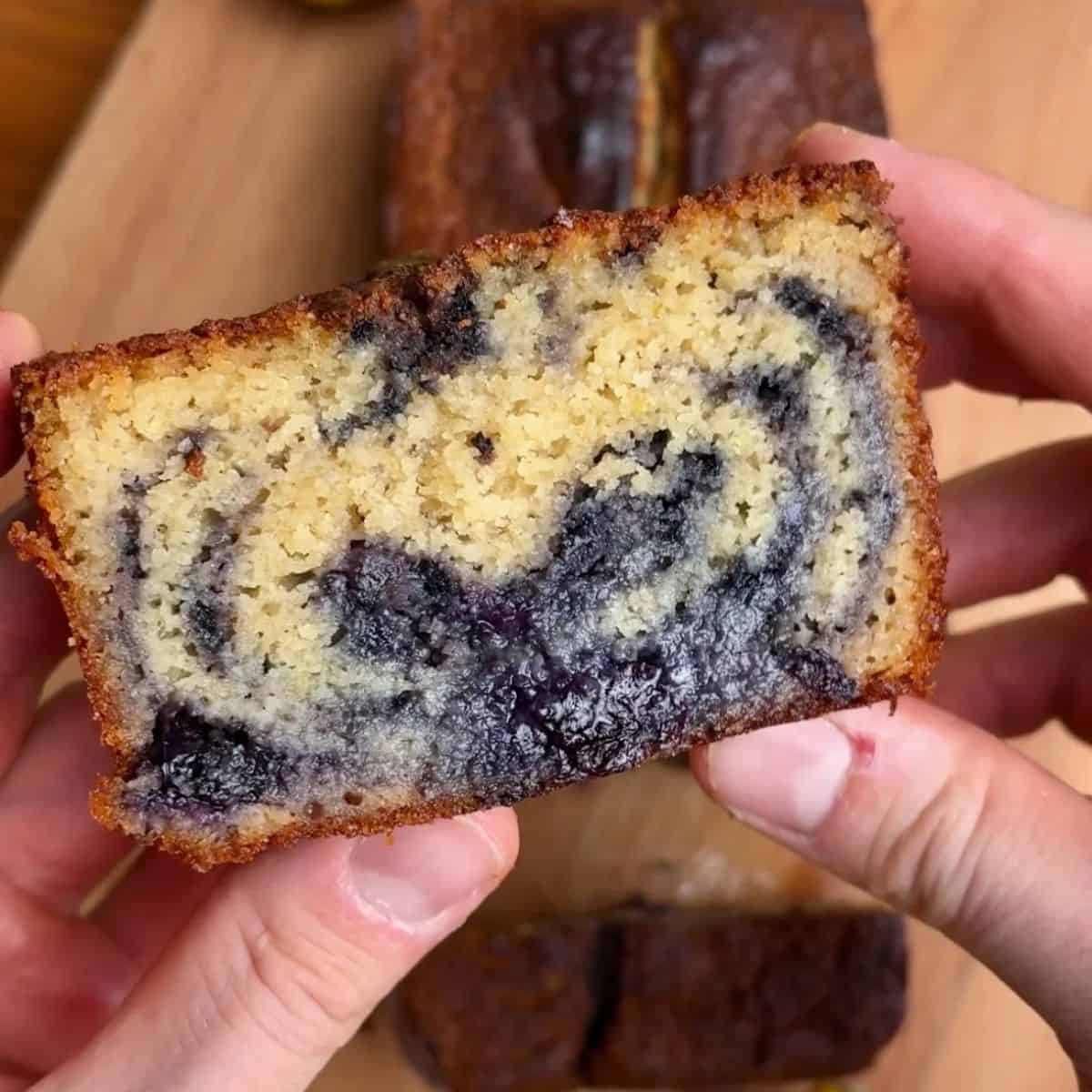 slice of lemon blueberry marble loaf with a moist, cake-like texture and blueberry swirl throughout