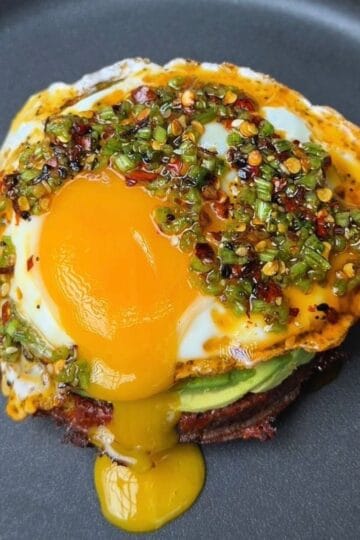 potato waffle breakfast stack with herby drizzle and runny egg yolk