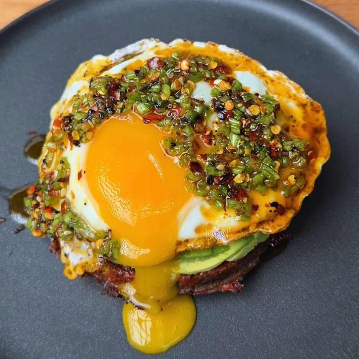 potato waffle breakfast stack with herby drizzle and runny egg yolk