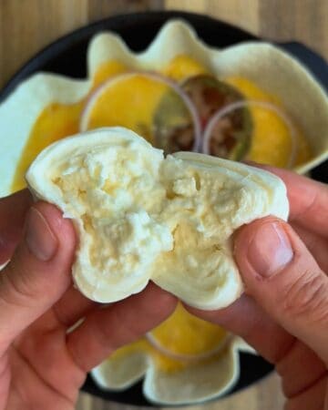 a ball of burrata split in half, prepared to add to the tomato burrata tortilla quiche
