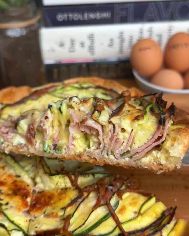 freshly baked slice crispy zucchini and ham tortilla quiche, with egg and melty cheese, in a golden brown tortilla
