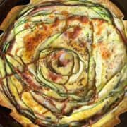 freshly baked crispy zucchini and ham tortilla quiche with golden brown edges and melty cheese