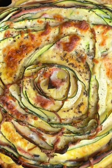 freshly baked crispy zucchini and ham tortilla quiche with golden brown edges and melty cheese