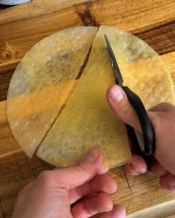 egg-washed rice paper being sliced for the making of a big mac rice paper croissant