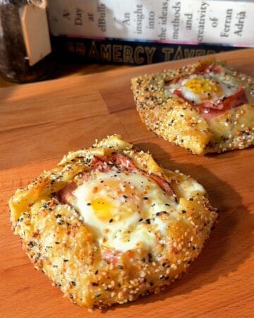 two crispy rice paper croque madams on a cutting board, fresh out of the oven
