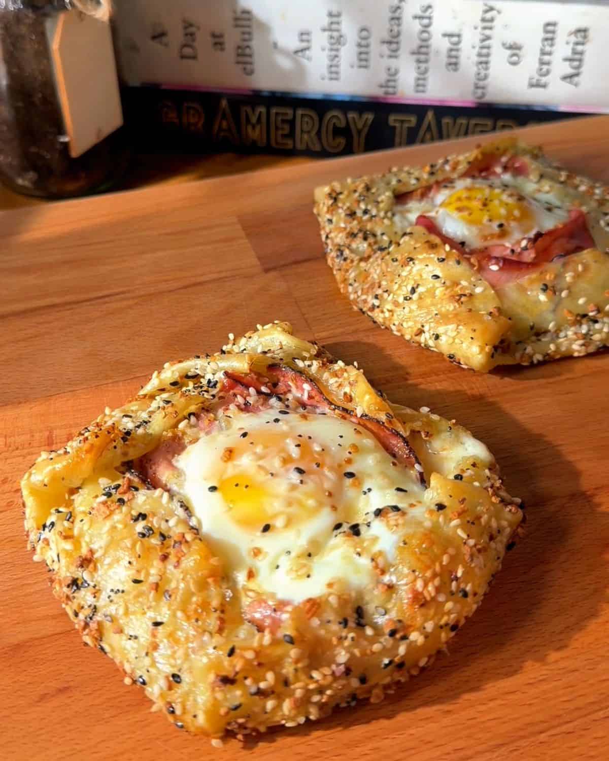 two crispy rice paper croque madams on a cutting board, fresh out of the oven