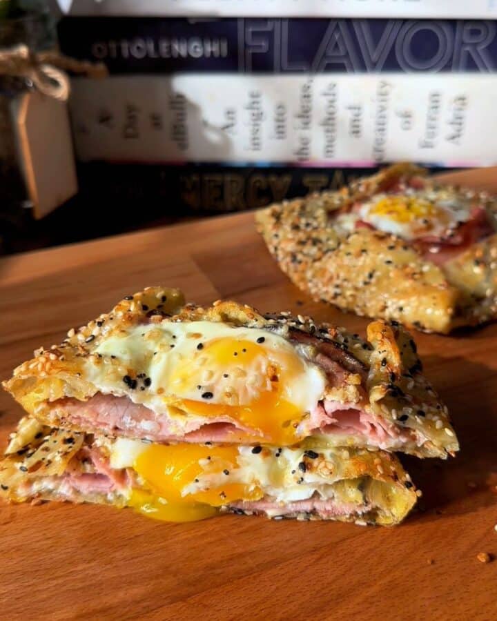a crispy rice paper croque madam cut in half, with egg yolk dripping out