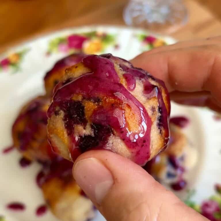 healthy baked blueberry donut hole drizzled with blueberry jam glaze