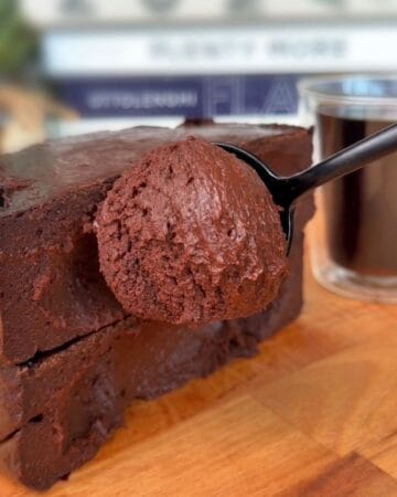 a spoon scooping the center of a creamy, dark chocolate coffee cheesecake