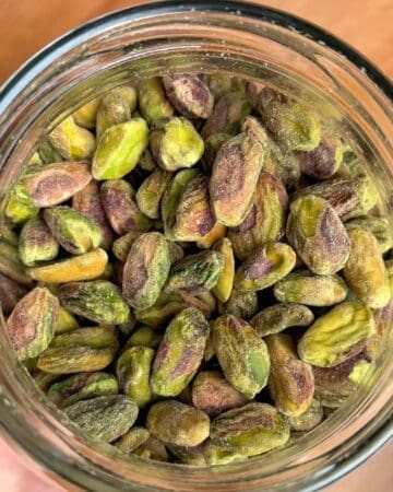 a mason jar of shelled pistachios for a homemade pistachio butter recipe
