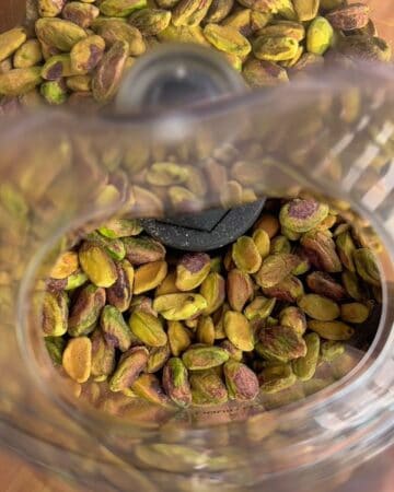 shelled pistachios in a food processor ready to be blended for homemade pistachio butter