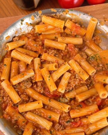 Hearty baked pasta dish topped with ground meat and tomato sauce, perfect for family dinners.