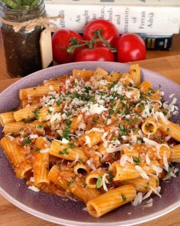 a bowl of one-pan cheesy tomato beef rigatoni with shredded parmesan and parsley on top