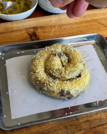 rice paper big mac spiral, rolled up on a cookie sheet, sprinkled with sesame seeds, ready for the oven