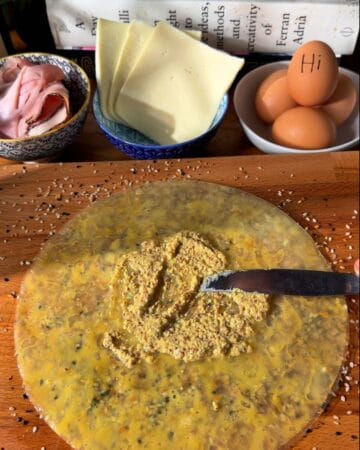 spreading dijon mustard on rice paper sheets, prepping a crispy rice paper croque madam