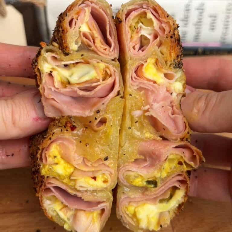 a crispy cuban rice paper sandwich cut in half, with melty cheese and crispy ham in the middle